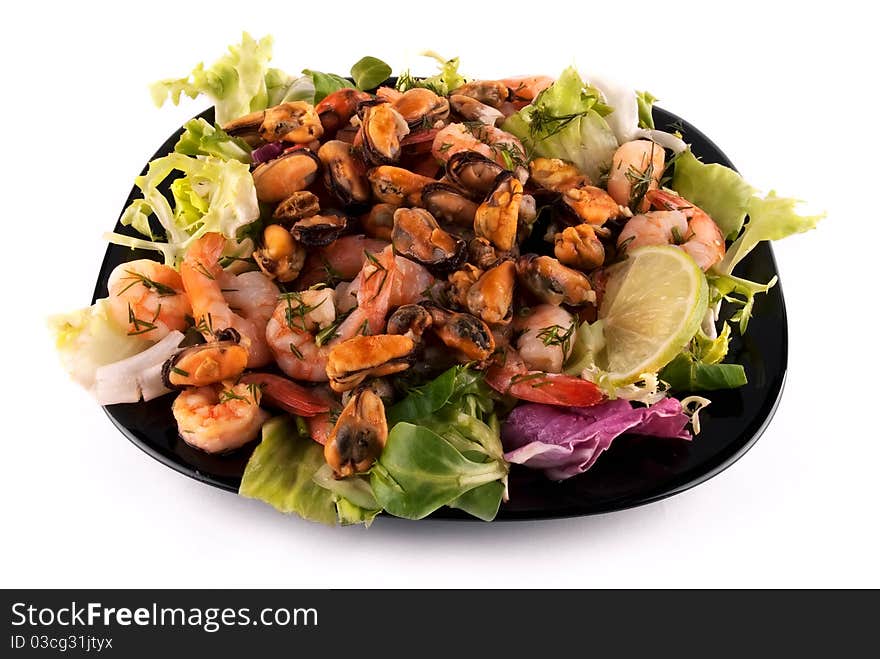 A salad with seafood on a black square plate