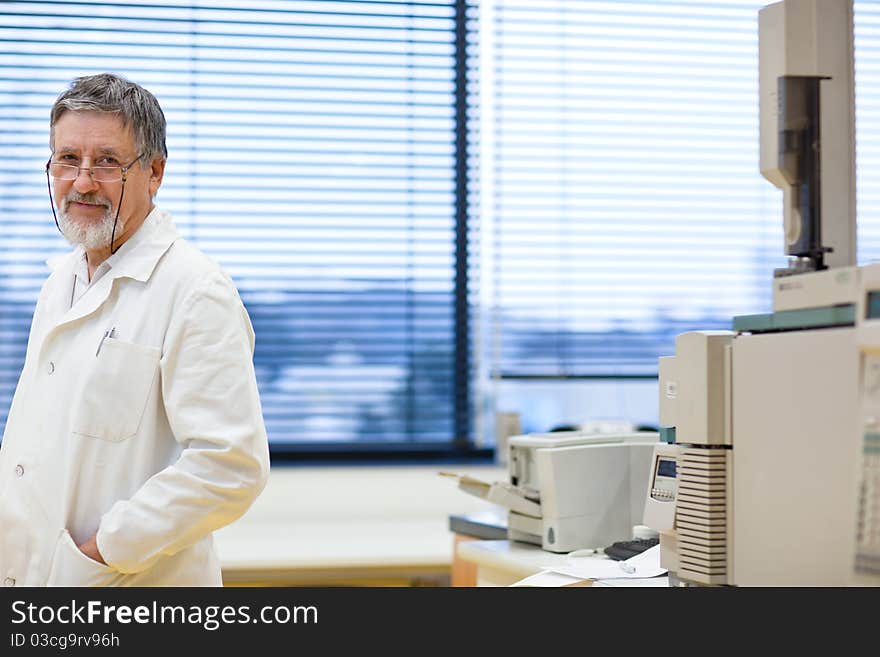 Renowned scientist/doctor in a research center/hospital laboratory looking confident (color toned image; shallow DOF)