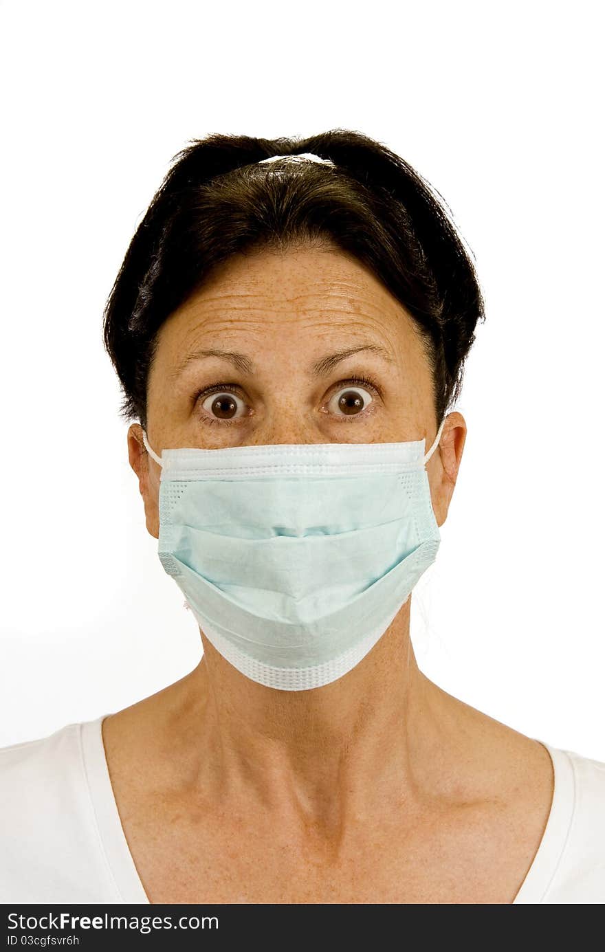 A surgical mask is used to protect from germs. This woman is fearful of catching something like the flu, etc. Isolated on white. Studio shot. A surgical mask is used to protect from germs. This woman is fearful of catching something like the flu, etc. Isolated on white. Studio shot.