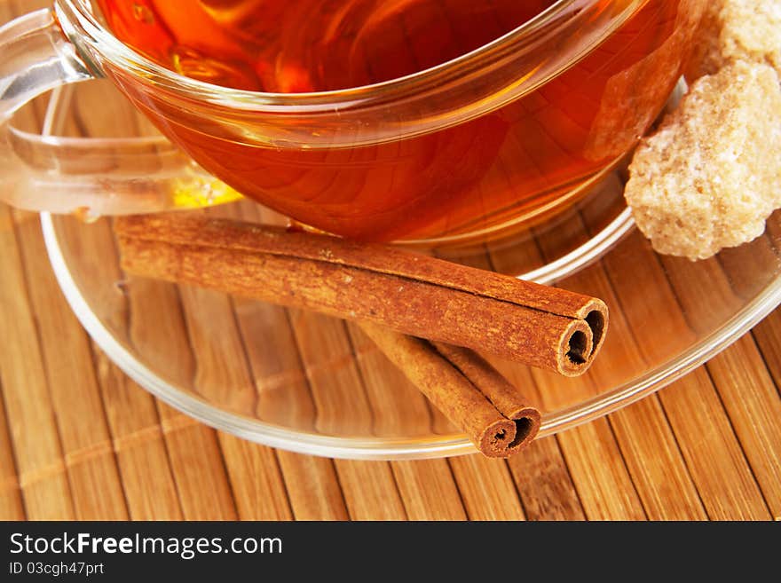 Glass cup of black tea with cinnamon and sugar