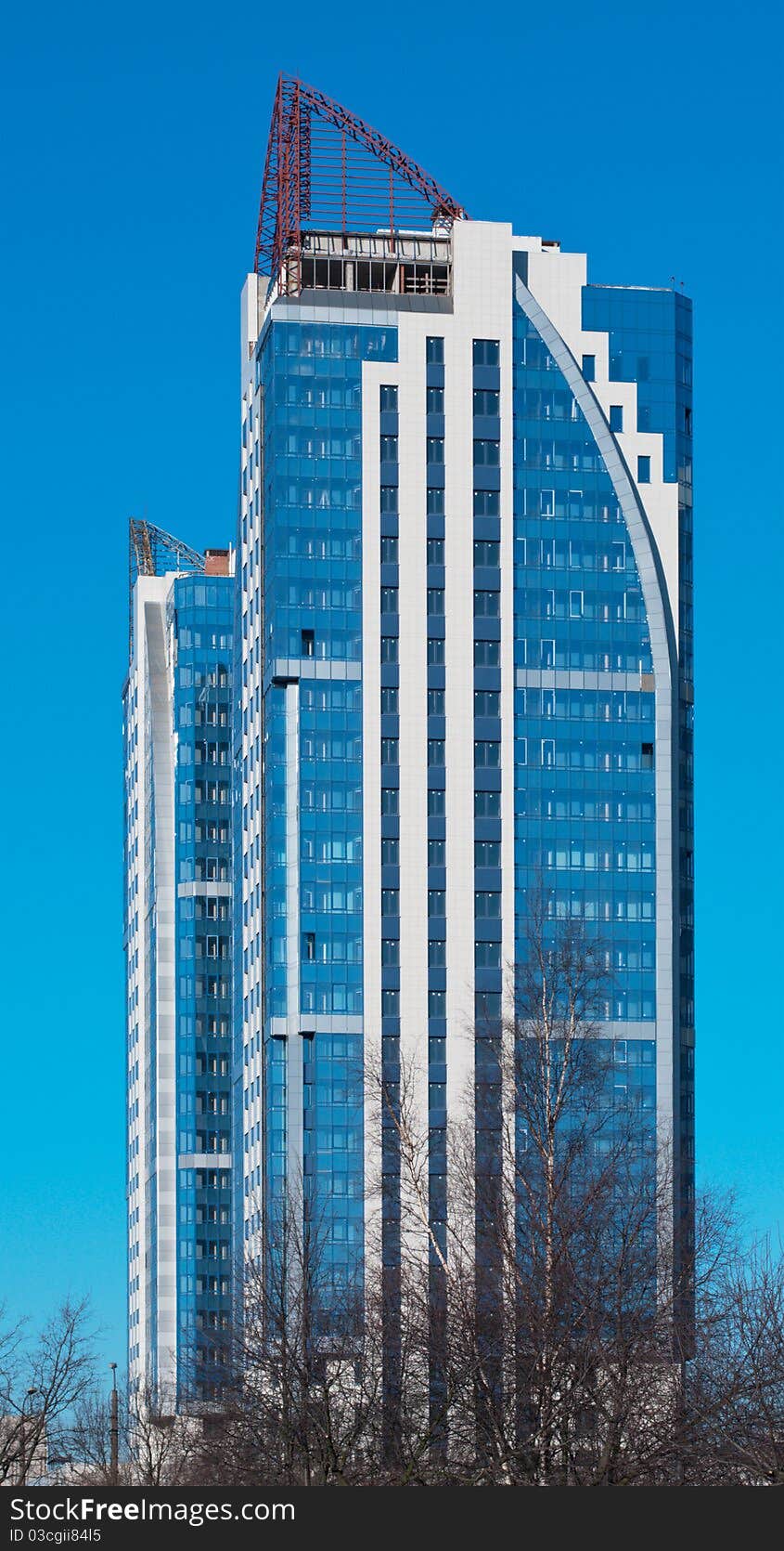 Modern high-rise apartment building against the blue cloudless sky.