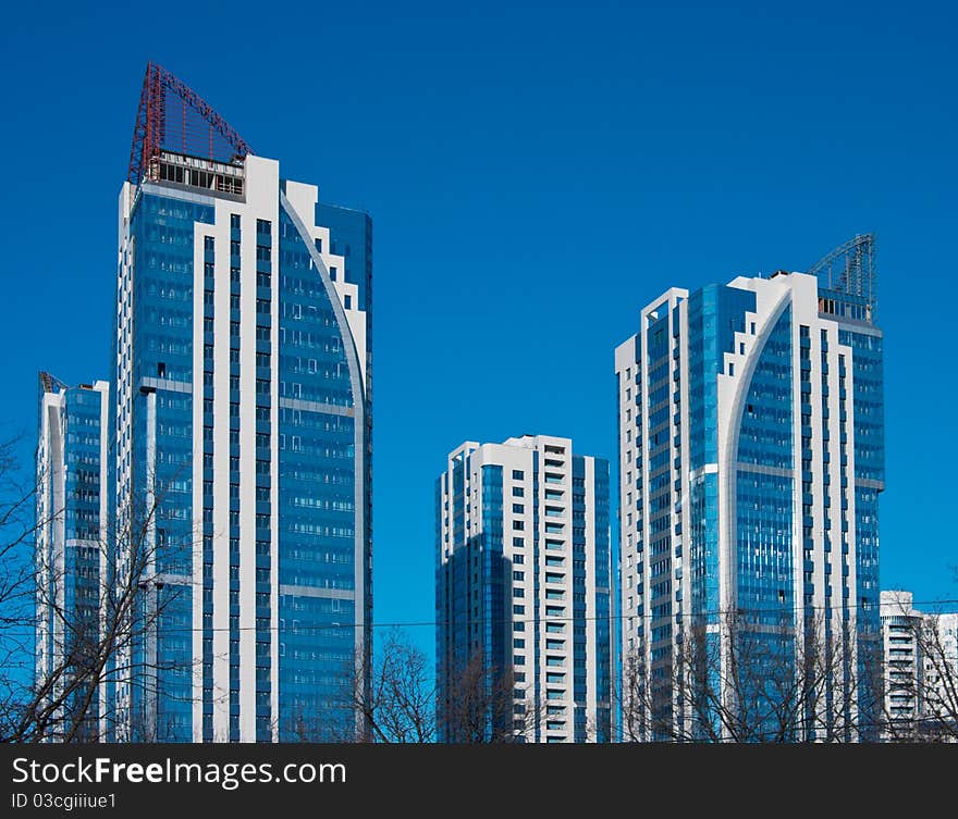 High-rise modern residential complex of four buildings on a background of blue sky. High-rise modern residential complex of four buildings on a background of blue sky.