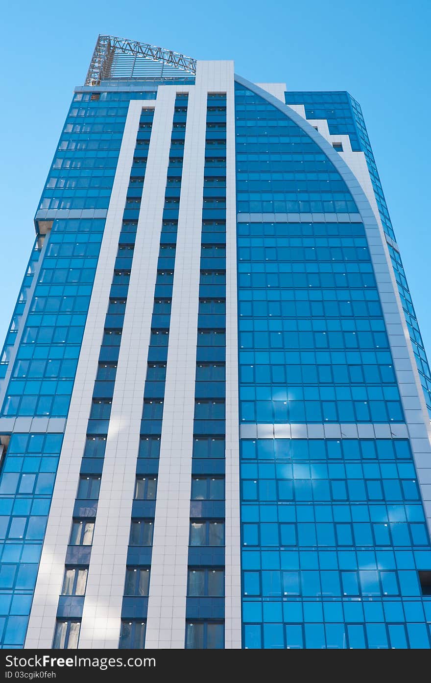 Modern high-rise apartment building against the blue cloudless sky.