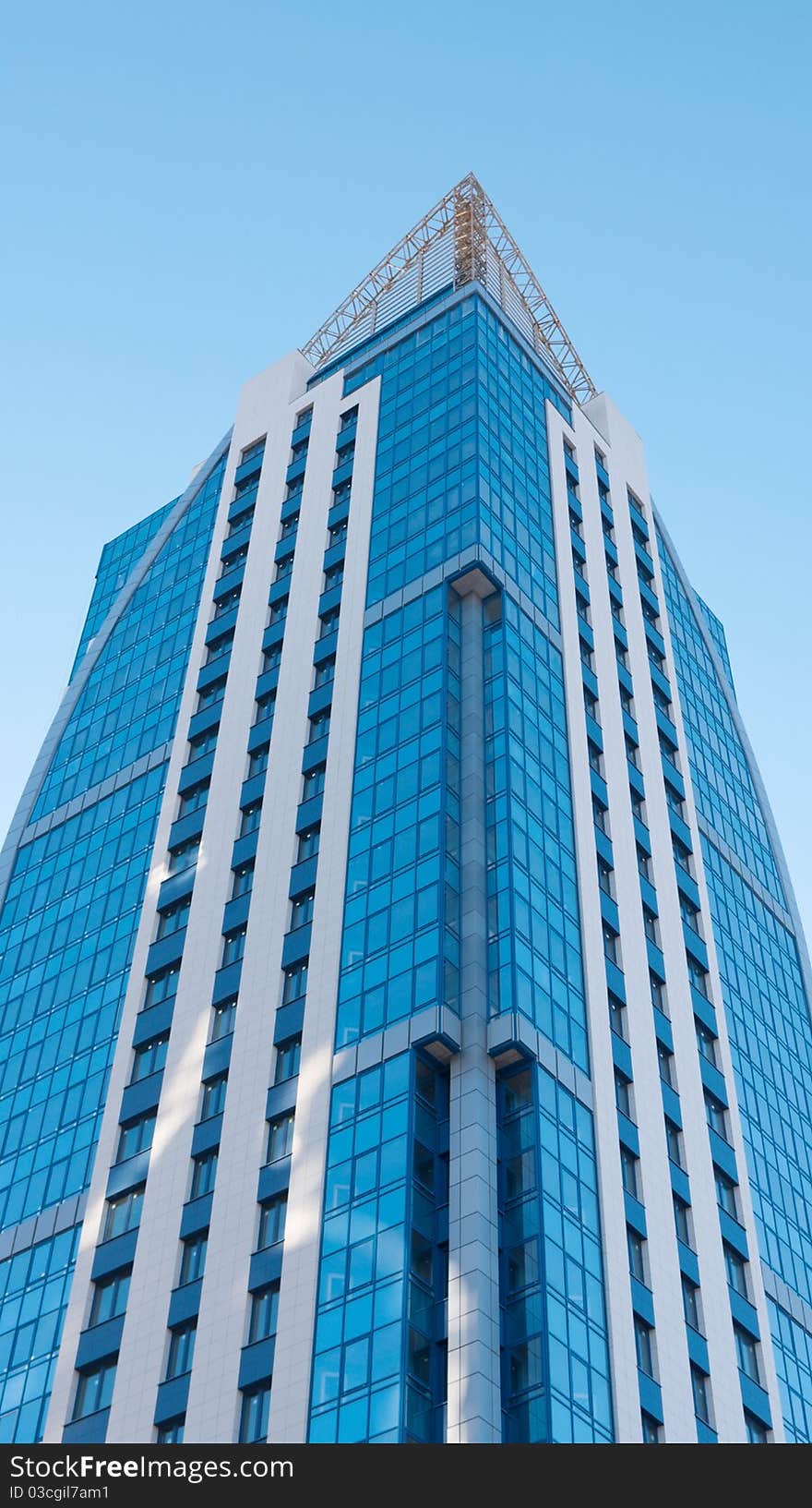 Modern high-rise apartment building against the blue cloudless sky.