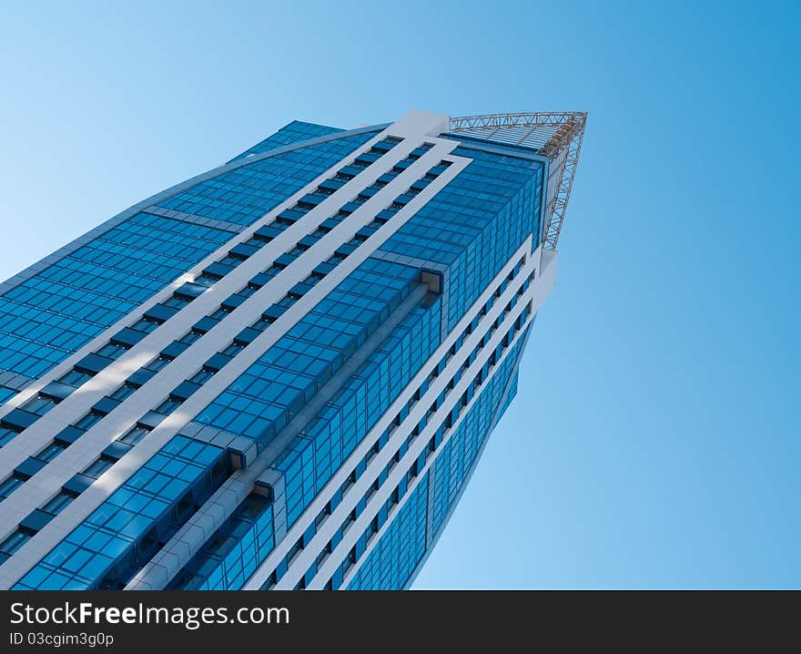 Modern high-rise apartment building against the blue cloudless sky.