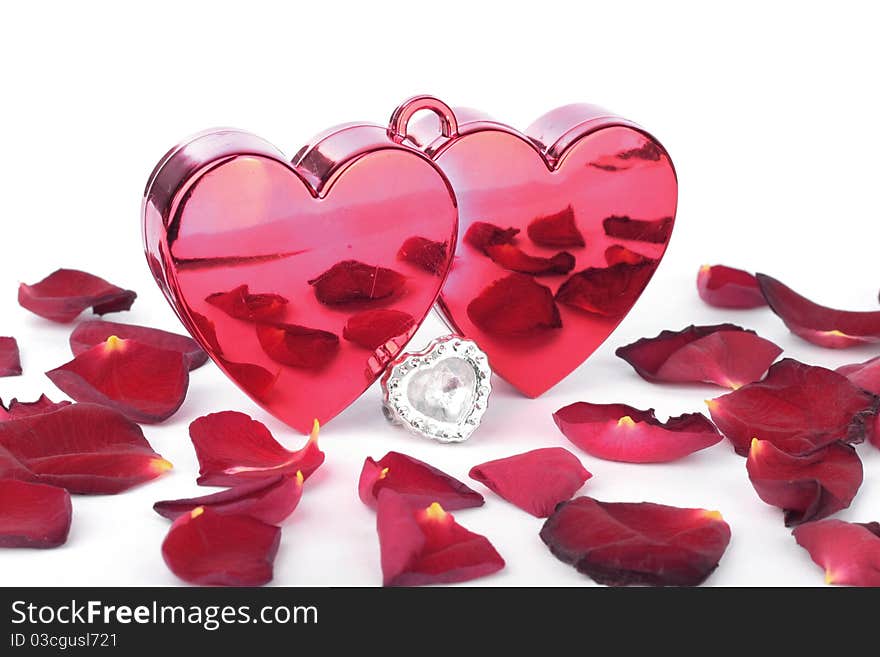 Red heart in box and petals on white background