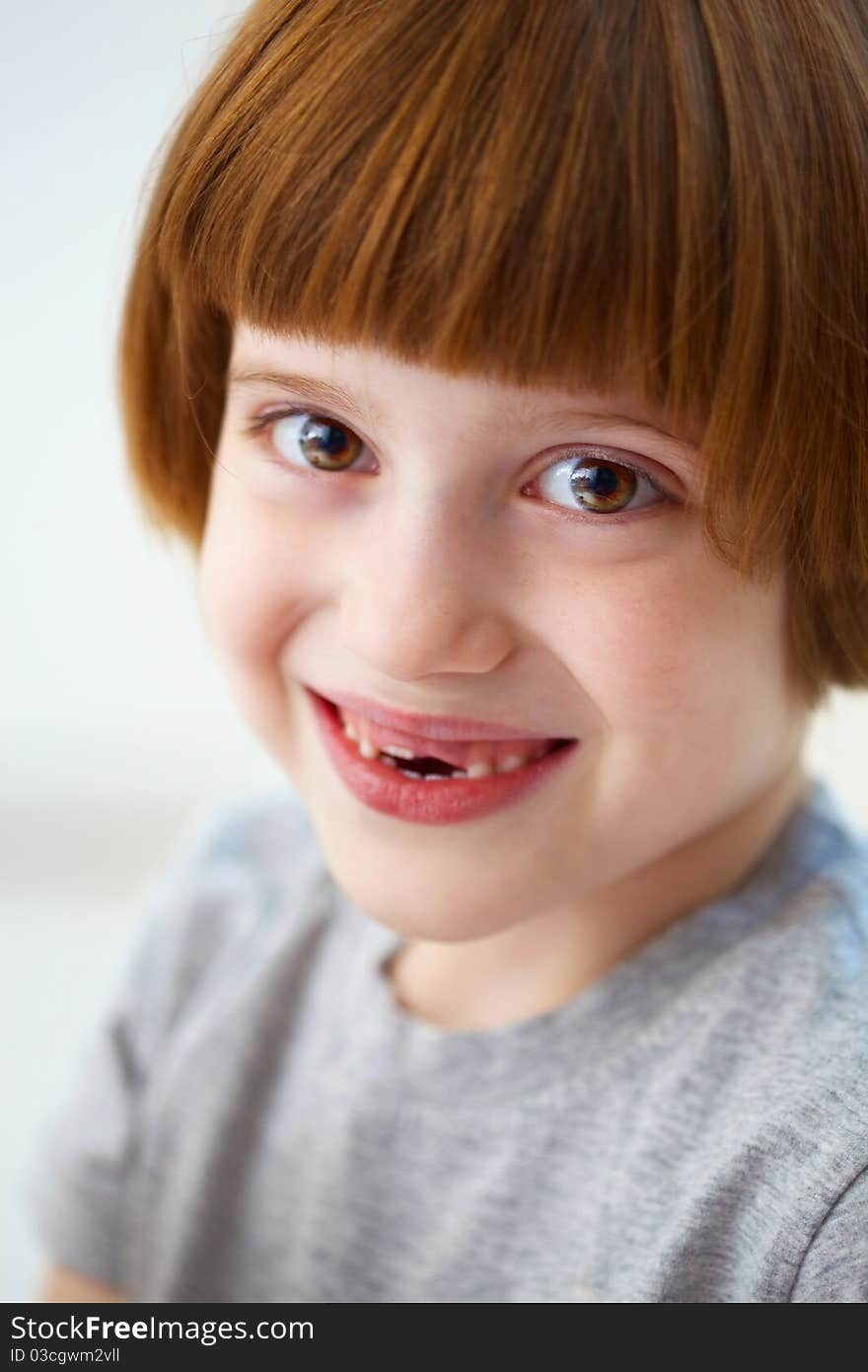 Closeup portrait of a cute smiling girl missing front teeth