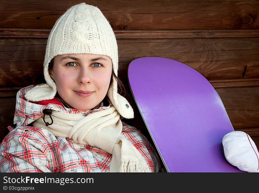 Smiling teenage girl holding snowboard