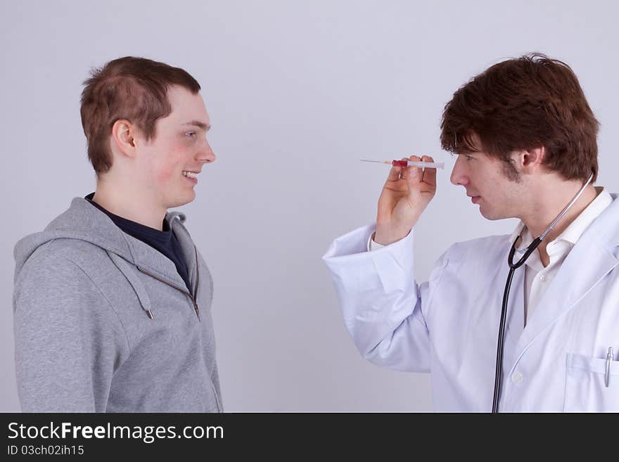 A young man gets an injection from a doctor. A young man gets an injection from a doctor