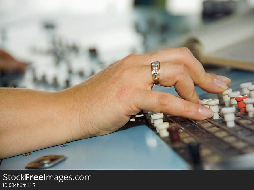 Woman's hands on the remote control in an industrial plant