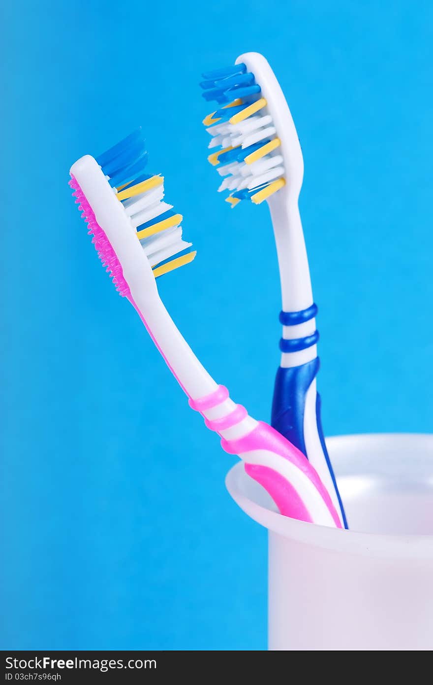 A couple of toothbrushes over blue background