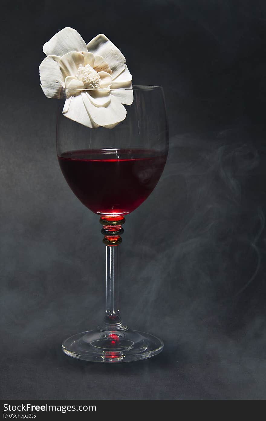 Glass of red wine and a flower isolated on black background. Glass of red wine and a flower isolated on black background