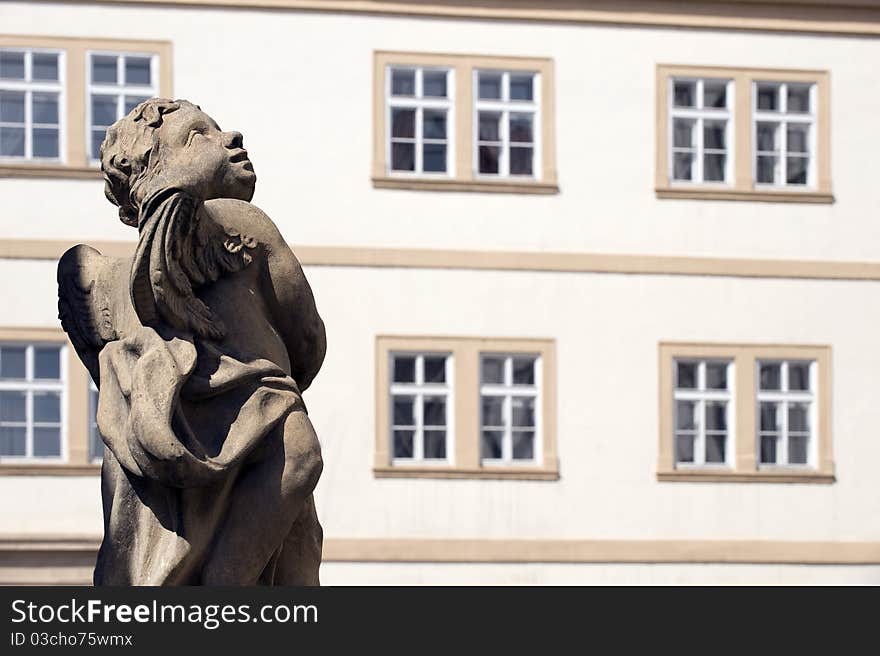 Windows and statue, old apartment building in Prague