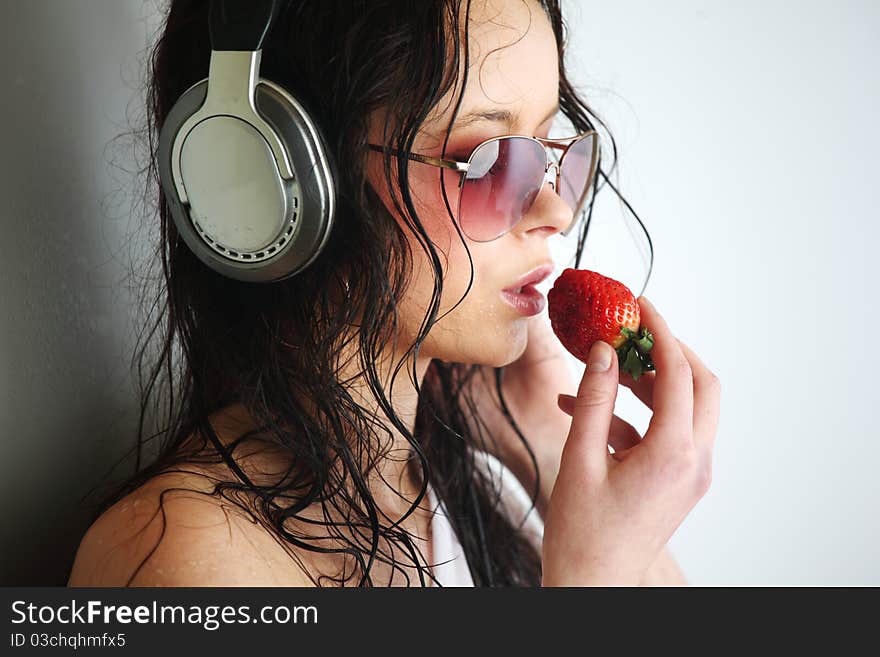 Happy woman dance in phones and eat strawberry. Happy woman dance in phones and eat strawberry