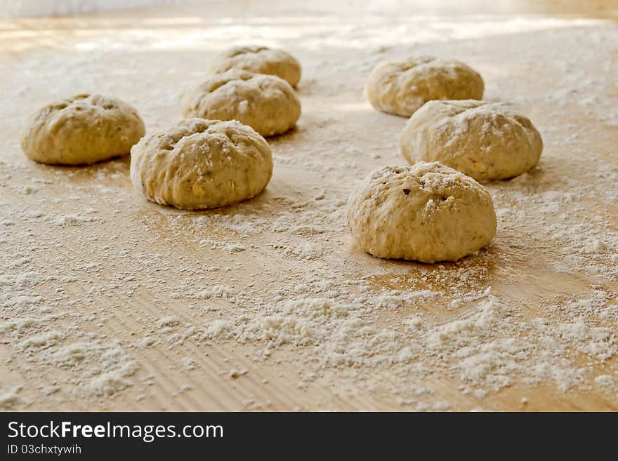 Bread dough balls on a table sprinkled with flour