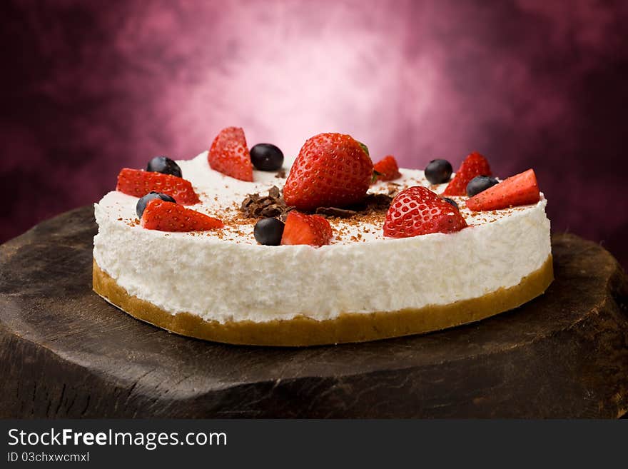 Photo of delicious cake with strawberries on wooden table