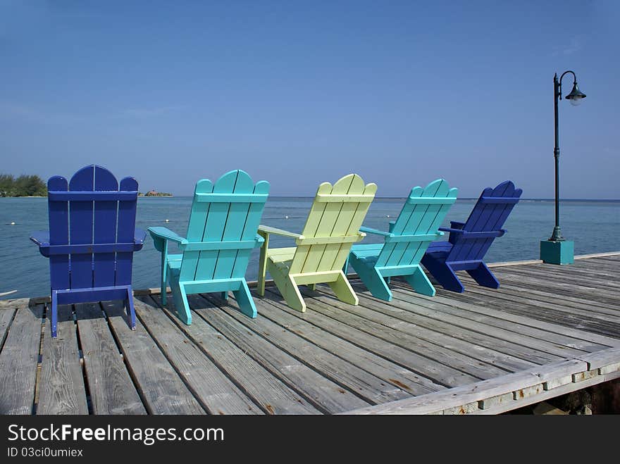 Colorful chairs on pier