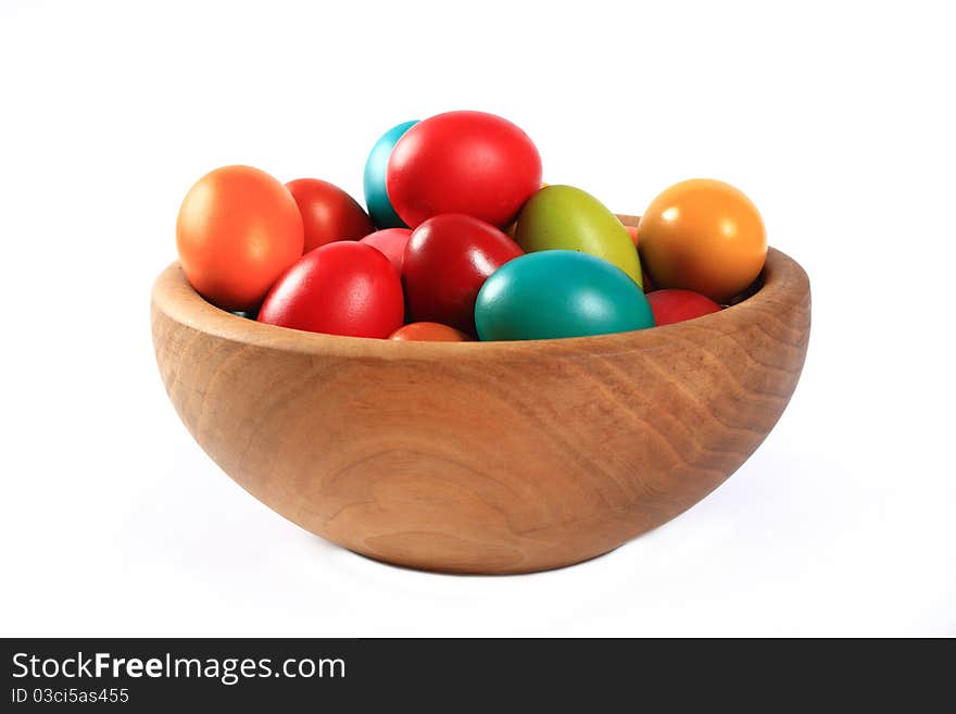 Easter eggs in a wooden bowl on a white background