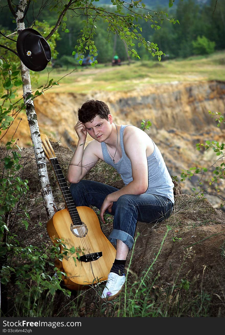 A lone young man with a guitar against breakage. A lone young man with a guitar against breakage