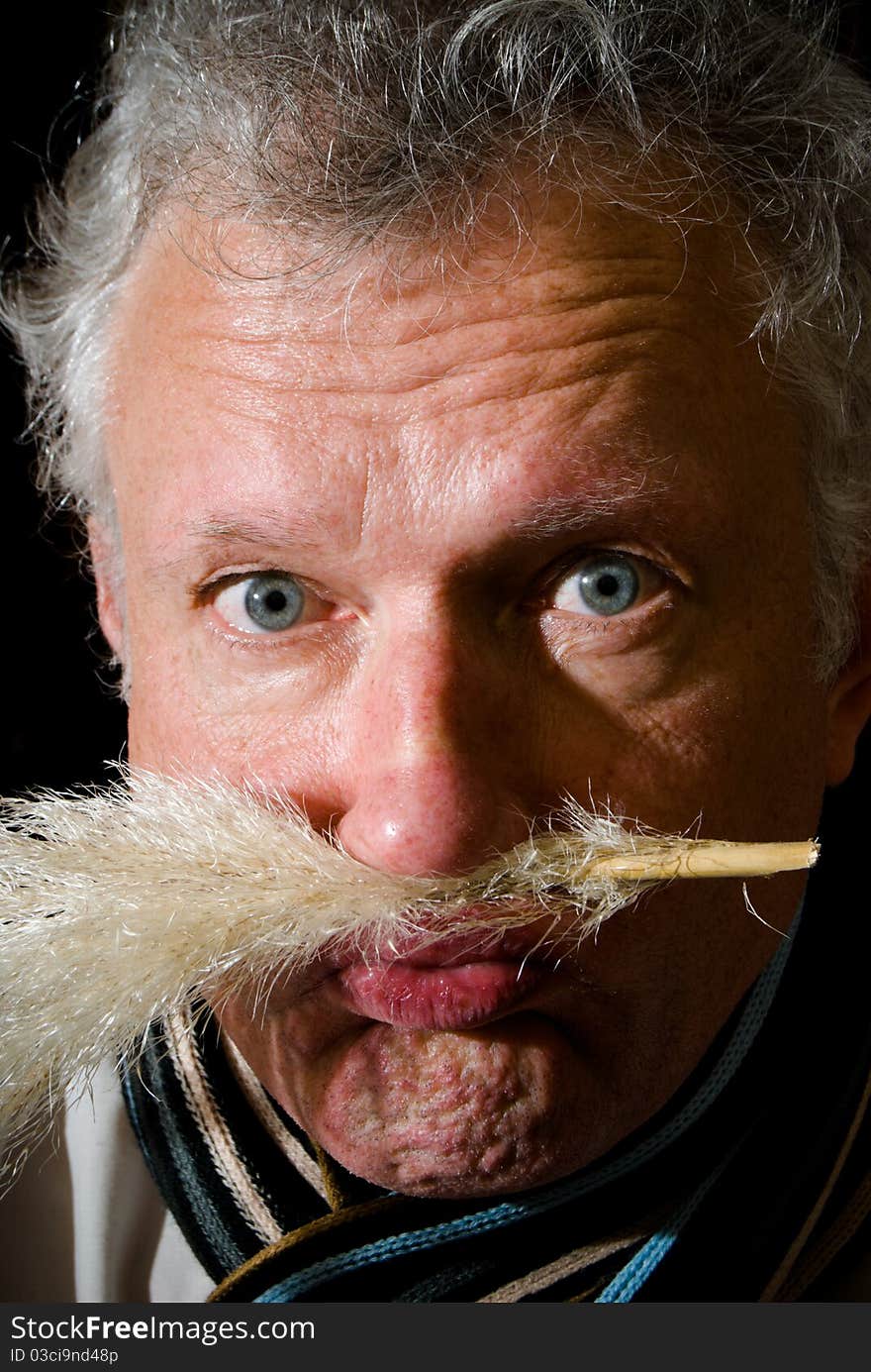 Portrait of a man with reed between lip and nose. Portrait of a man with reed between lip and nose