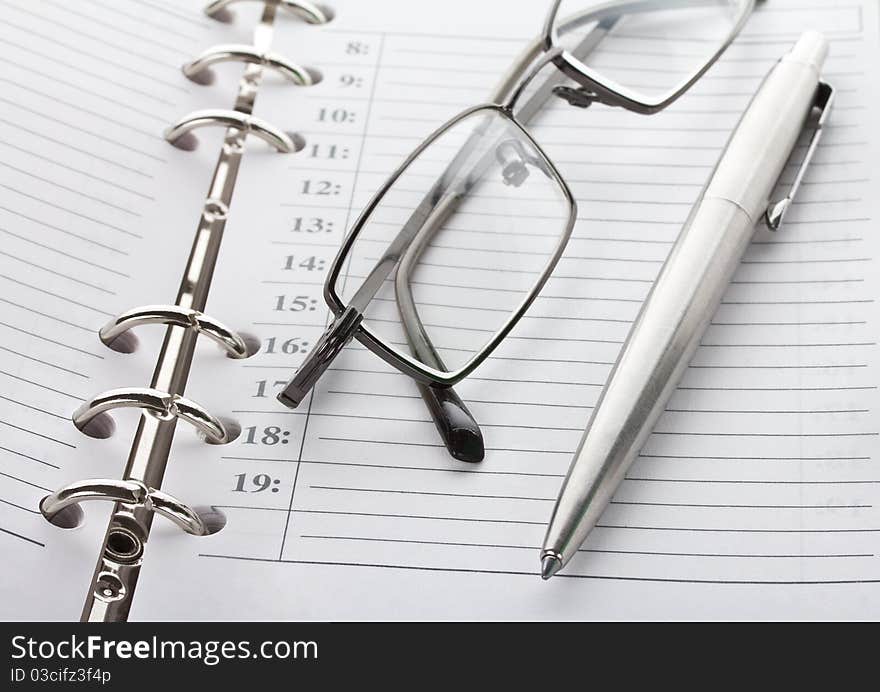 Close-up notebook, pen and glasses