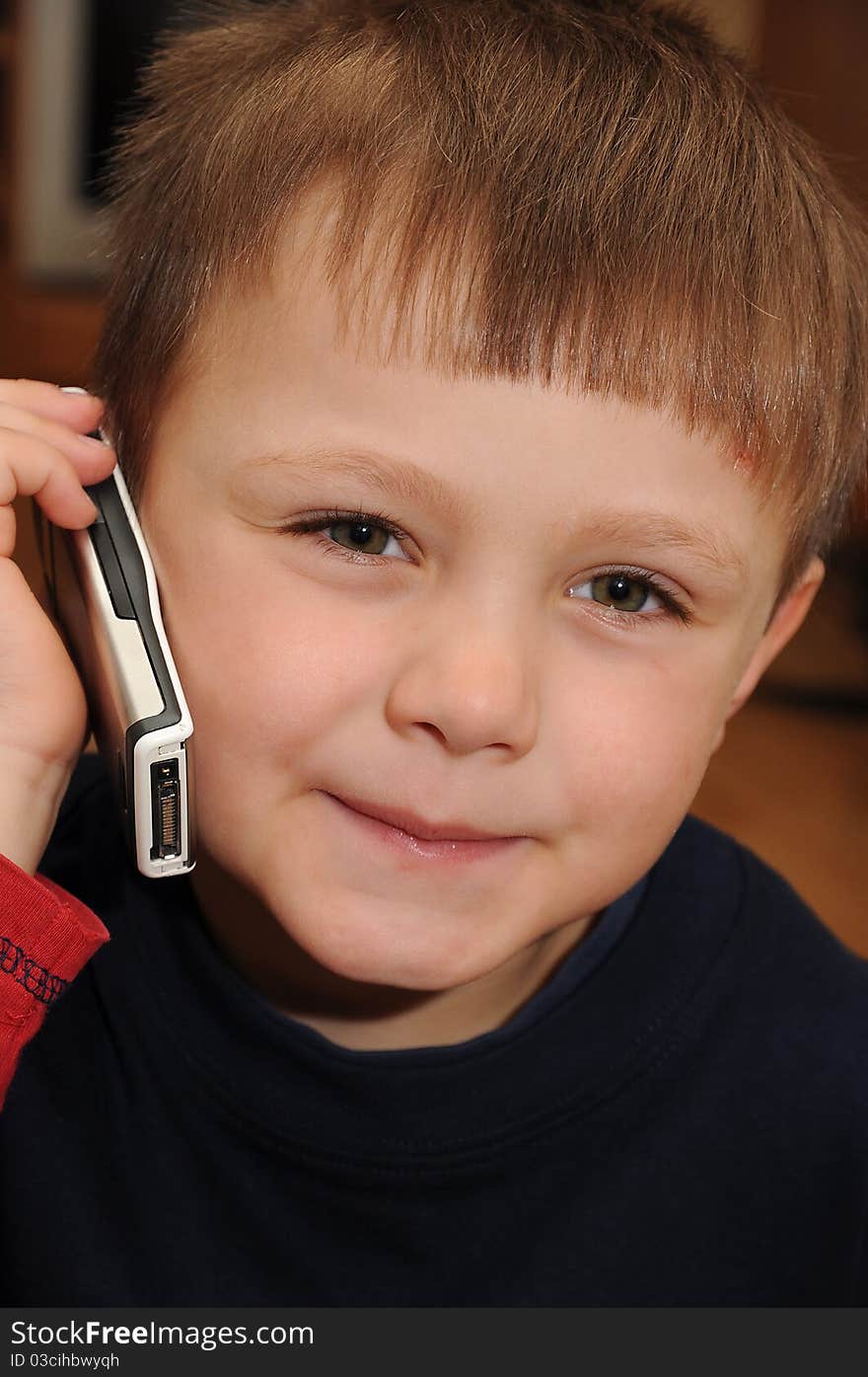 Young child holding a mobile phone and making a call. Young child holding a mobile phone and making a call