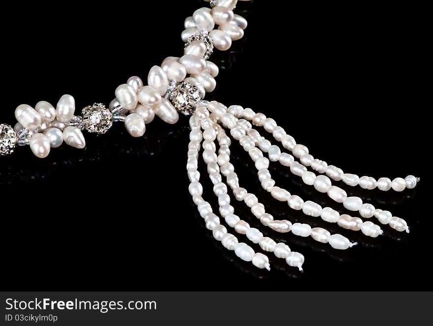 White necklace of pearls and diamonds in a black background. White necklace of pearls and diamonds in a black background