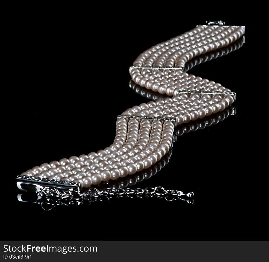 White necklace of pearls and diamonds in a black background. White necklace of pearls and diamonds in a black background