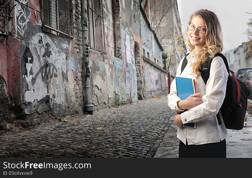 Smiling beautiful student on a city street