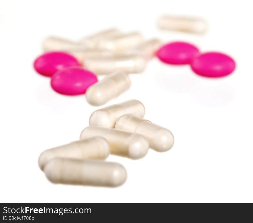 Pink and white pills on a white background. Pink and white pills on a white background