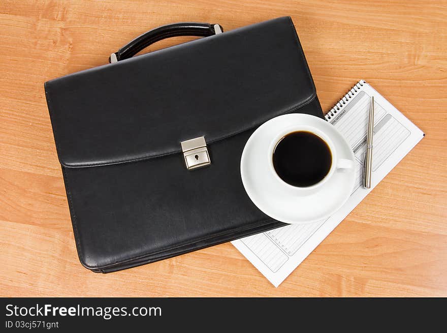 Black portfolio and coffee on a table