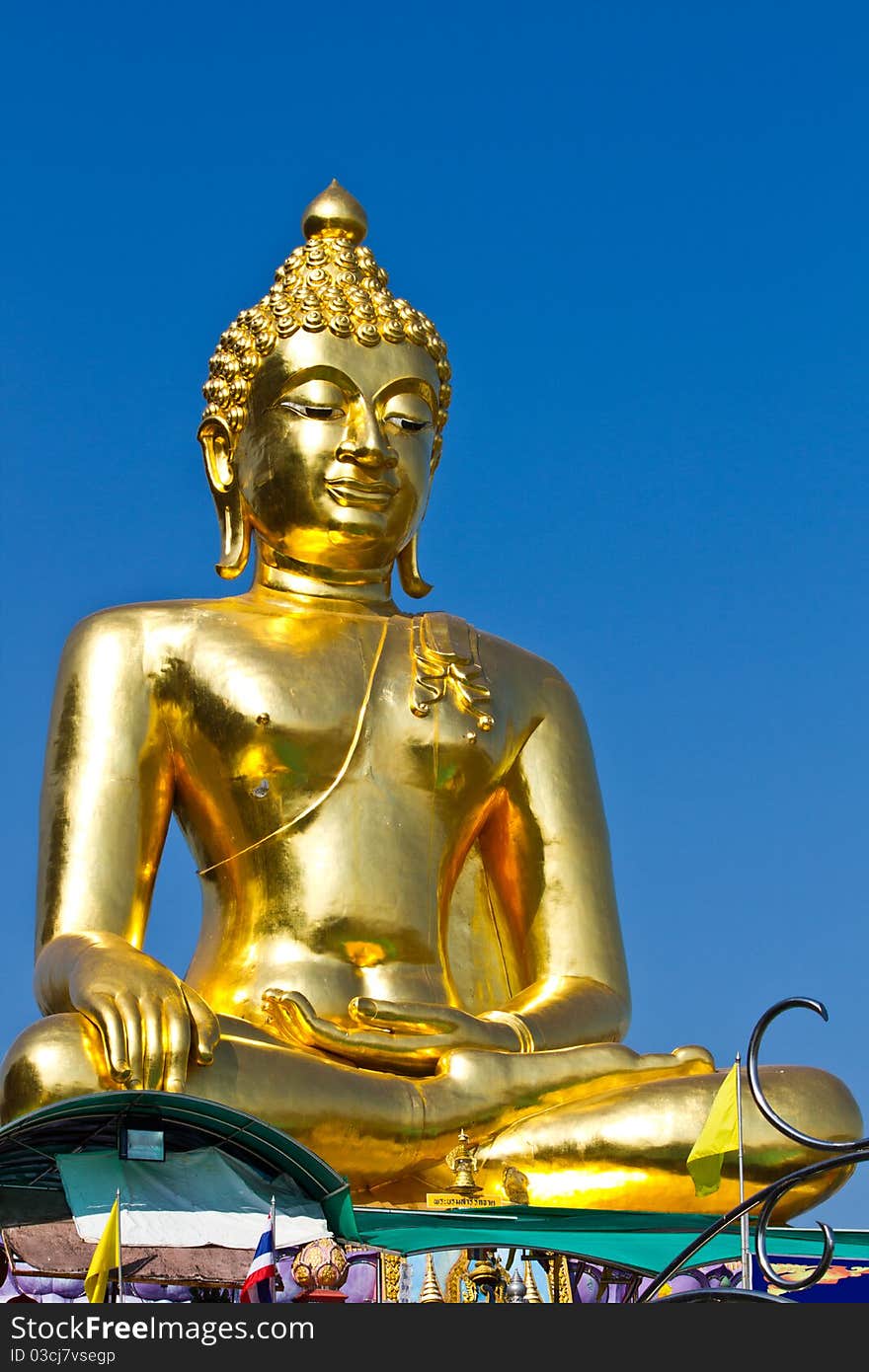 The smiling golden buddha statue under the open sky. The smiling golden buddha statue under the open sky