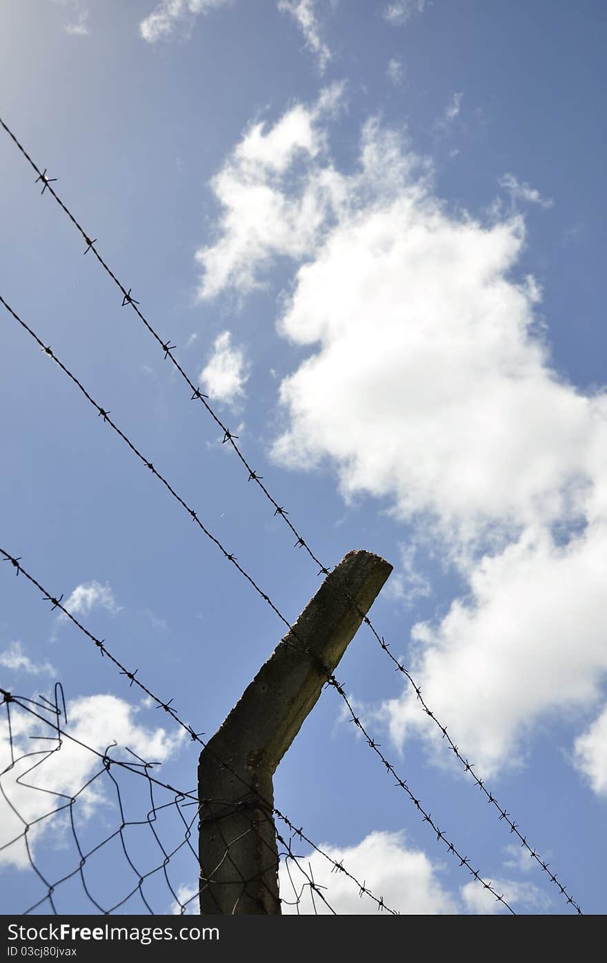 Fence With Barbed Wire Under Blue Sky