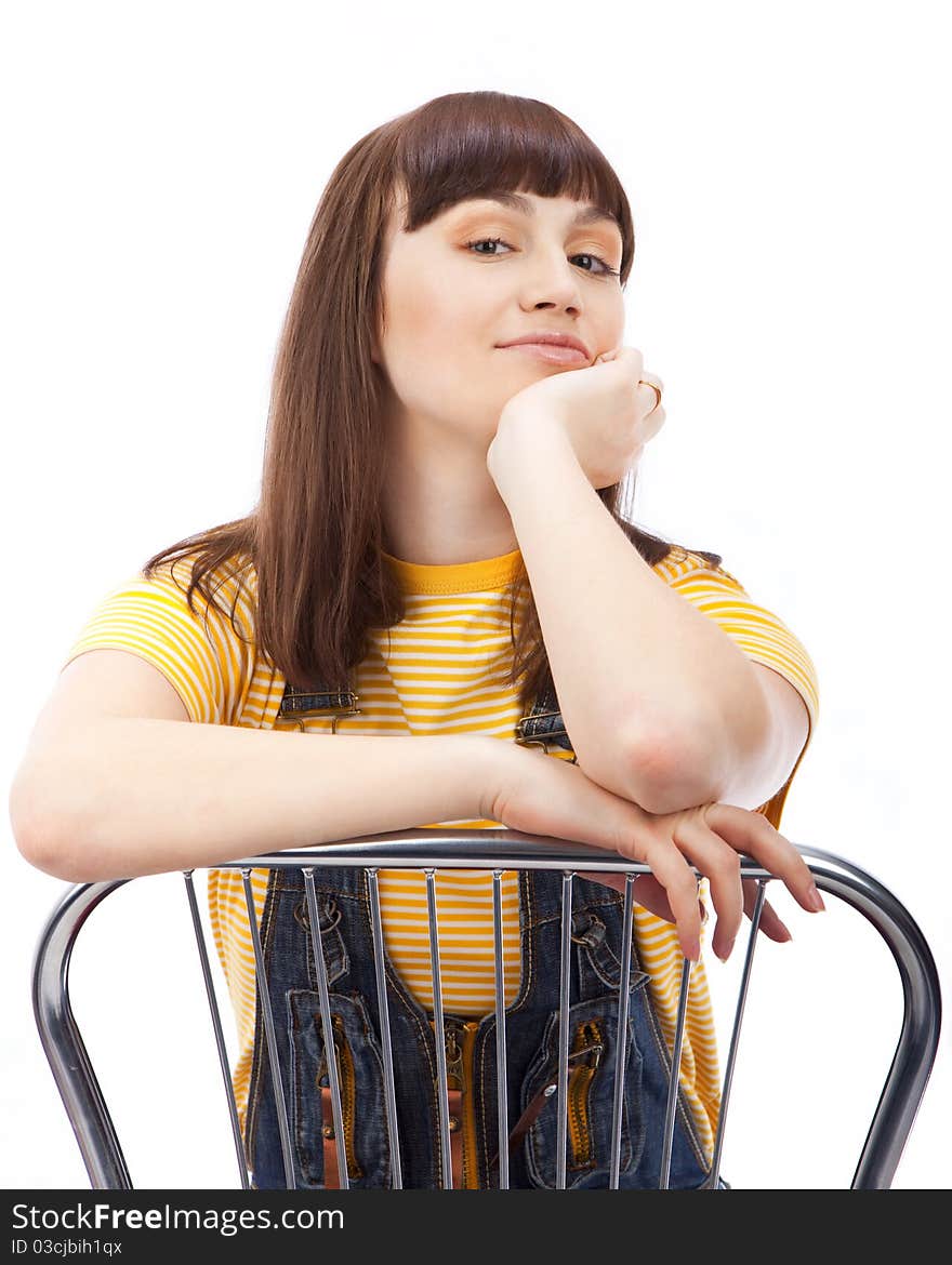 Positive adult woman sitting on a chair on a white background isolated