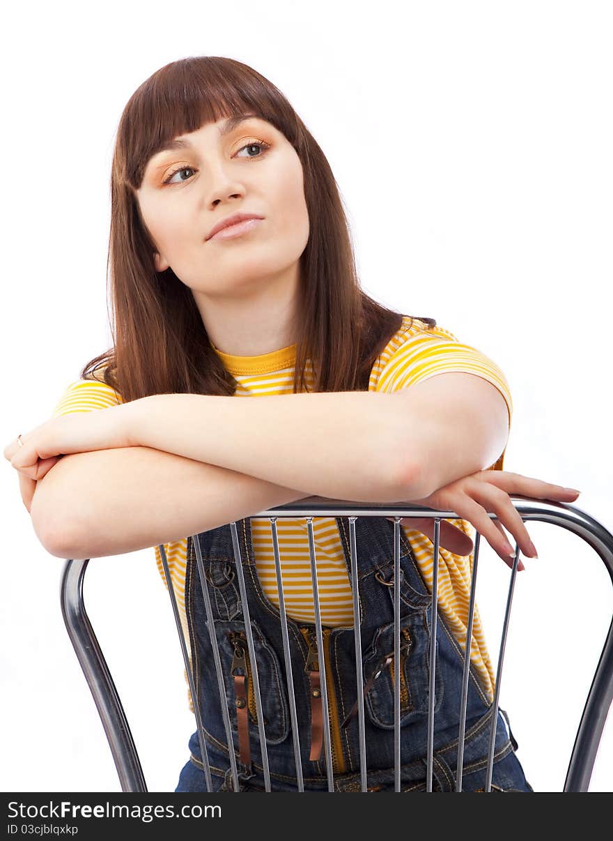 Positive adult woman sitting on a chair on a white background isolated