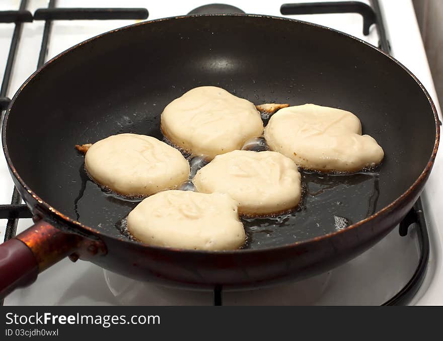 Raw pancakes are fried in a pan