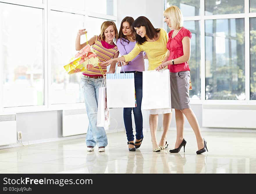 Happy young adults standing in mall with shopping bags. Happy young adults standing in mall with shopping bags