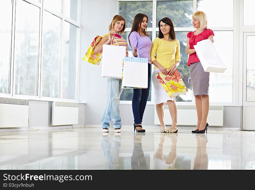 Happy young adults standing in mall with shopping bags. Happy young adults standing in mall with shopping bags