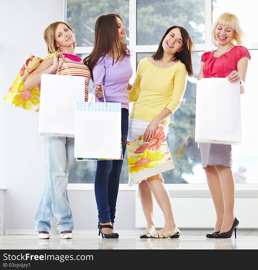 Happy young adults standing in mall with shopping bags. Happy young adults standing in mall with shopping bags