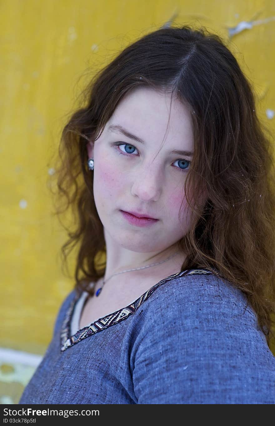 Young girl with wavy hair on the yellow background. Young girl with wavy hair on the yellow background