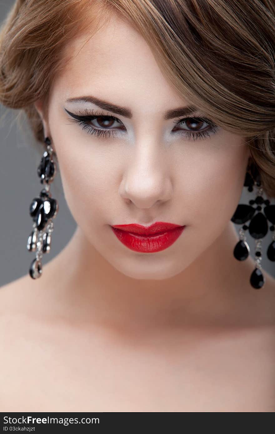 Beauty, close-up portrait of a young, blonde woman, wearing a retro makeup look, with red lips and black eyeliner, smiling, looking straight into the camera. Beauty, close-up portrait of a young, blonde woman, wearing a retro makeup look, with red lips and black eyeliner, smiling, looking straight into the camera.