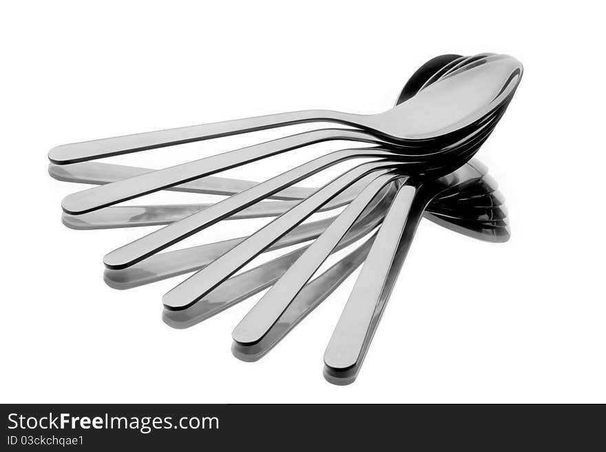 Six spoons spread as a fan on reflecting background