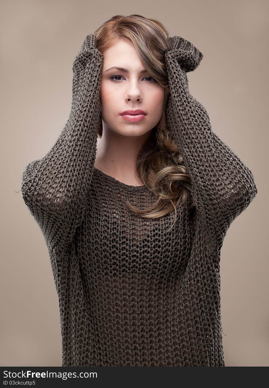 A beauty portrait of a beautiful, young, blonde woman. she holds both her hands on her head and she is smiling. A beauty portrait of a beautiful, young, blonde woman. she holds both her hands on her head and she is smiling