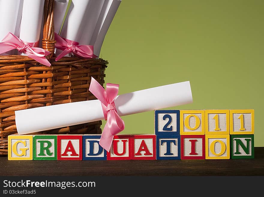 Diploma tied with a ribbon, the text of the wooden blocks Graduation 2011.