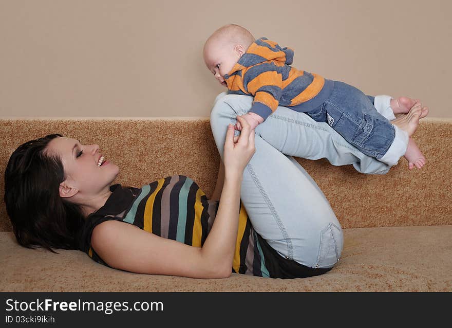 Young mum plays with the cheerful baby. Young mum plays with the cheerful baby