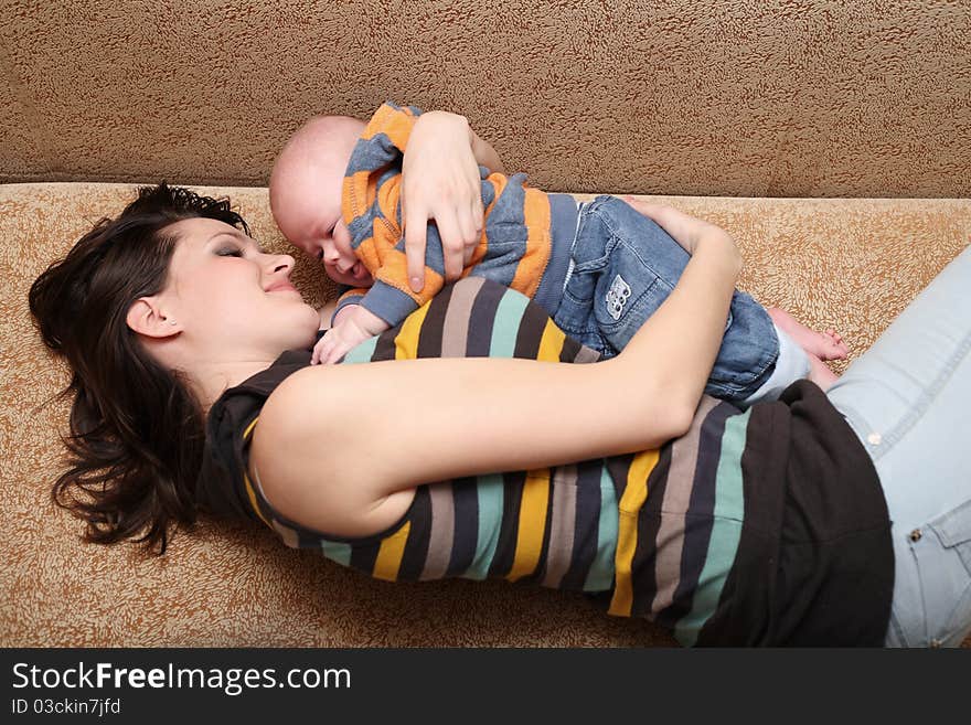 Young mum plays with the cheerful baby. Young mum plays with the cheerful baby