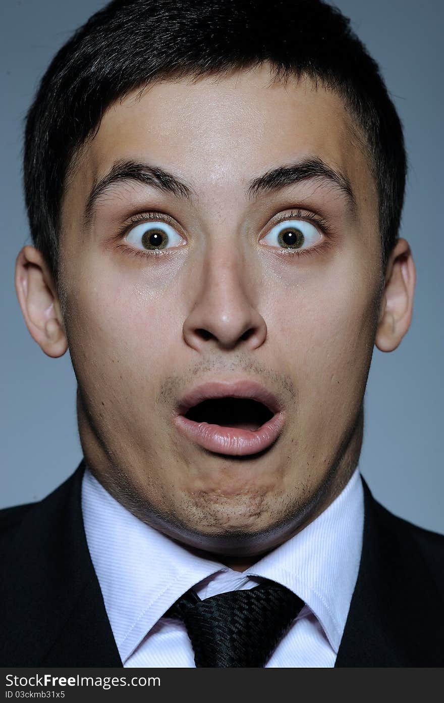 Portrait of stressed business man in formal suit and black tie having problems. gray background