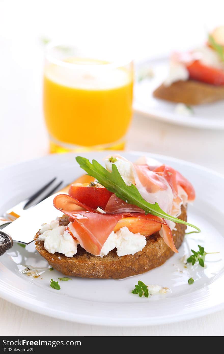 Sandwich with ham, fresh peach and soft goat cheese on white plate. Sandwich with ham, fresh peach and soft goat cheese on white plate