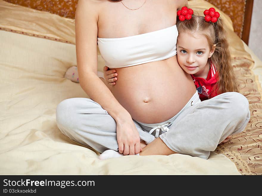 A girl and her pregnant mother at home