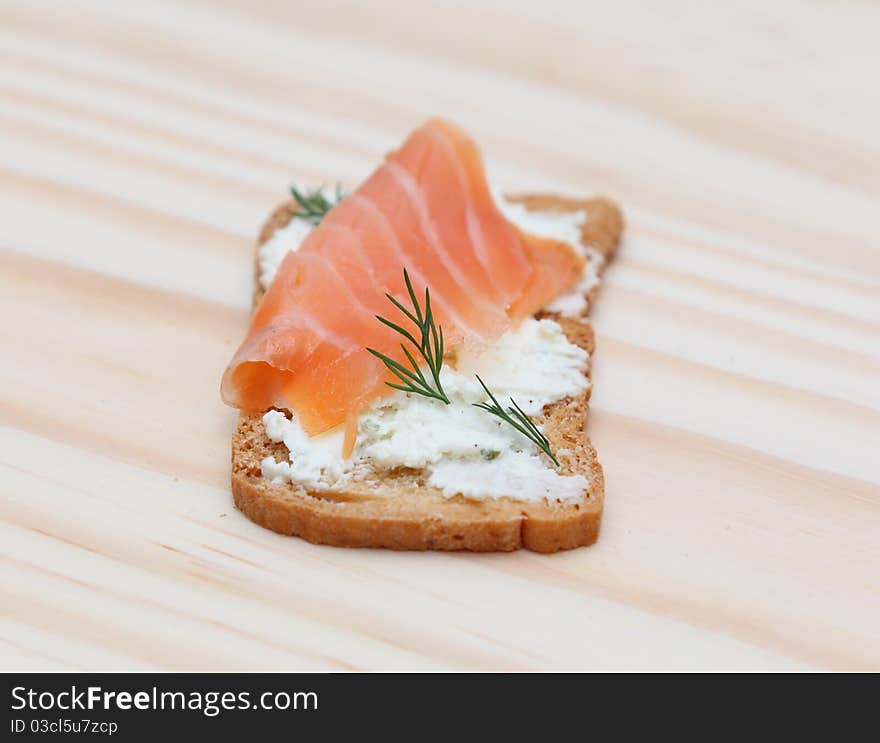 Image of a tasty with salmon meat cheese and dill on a wooden table. Image of a tasty with salmon meat cheese and dill on a wooden table.